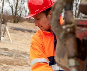 Wellsite consultant in a hard hat inspecting equipment
